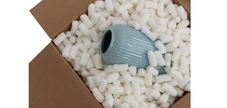 Biodegradable packing peanuts in a box covering a ceramic vase