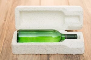 Green wine bottle protected by compostable mushroom packaging
