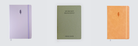 A pink, dark green, and orange notebook from The Scribes brand